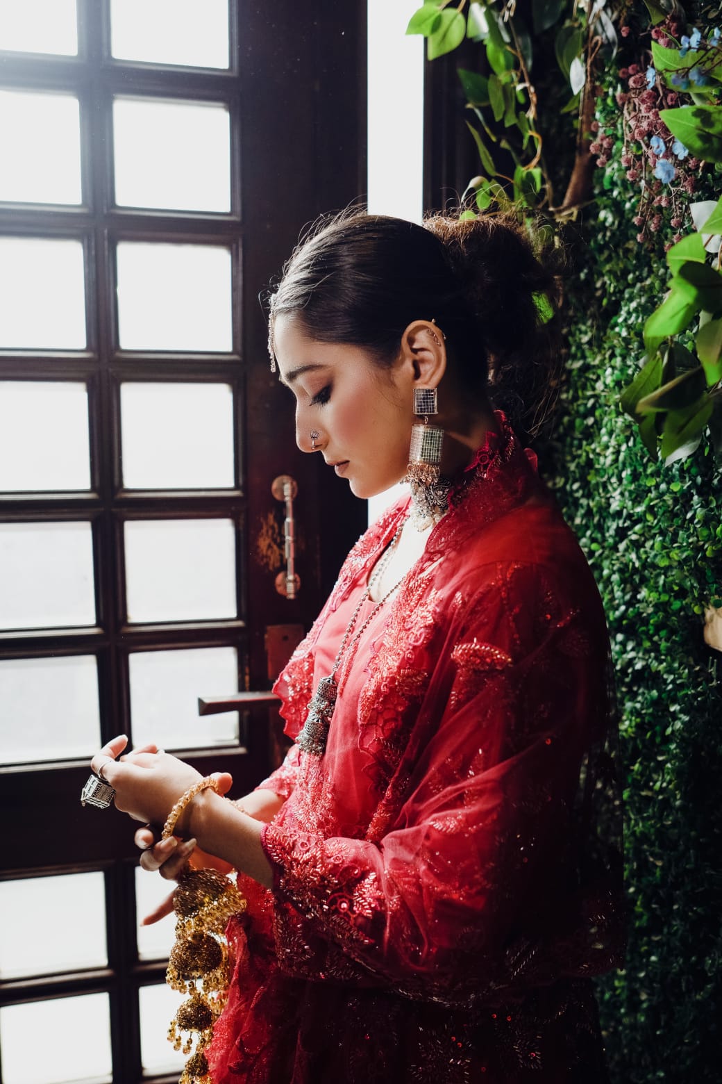 Displaying her earrings as she arranges the bangles.